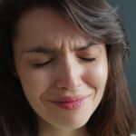 Woman with eyes closed and wrinkled nose